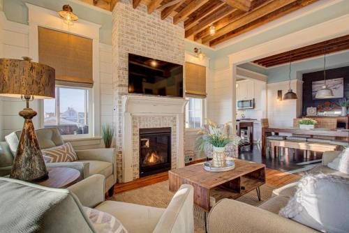 a living room with a fireplace and a table at 4115 - Coastal Cottage in Kitty Hawk