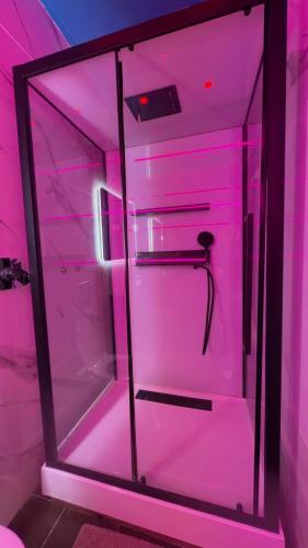 una stanza rosa con un frigorifero con una luce rosa di LoVe 3 a Cap d'Agde