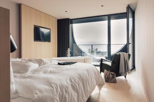 a hotel room with a bed and a large window at Hotel Milla Montis in Maranza