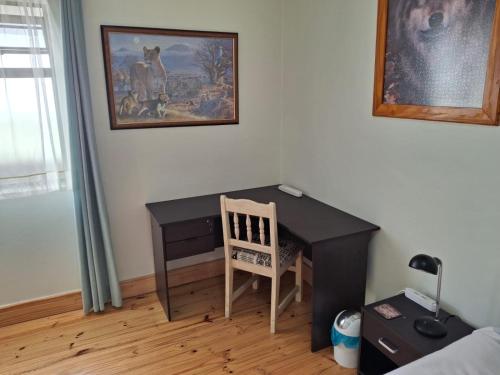 a desk with a chair and a picture on the wall at R & A's Cottage in Strand