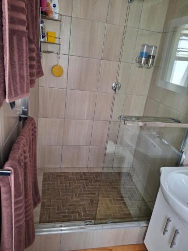 a bathroom with a shower with a glass door at R & A's Cottage in Strand