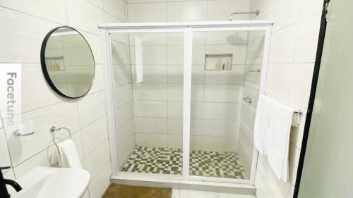 a bathroom with a shower with a sink and a mirror at Fourways Luxury Residence in Four Ways