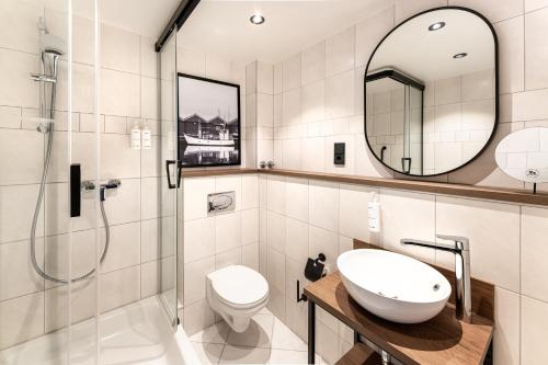 a bathroom with a toilet sink and a shower at Hotel Astor Kiel by Campanile in Kiel