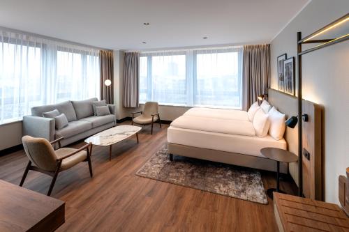 a hotel room with a bed and a living room at Hotel Astor Kiel by Campanile in Kiel