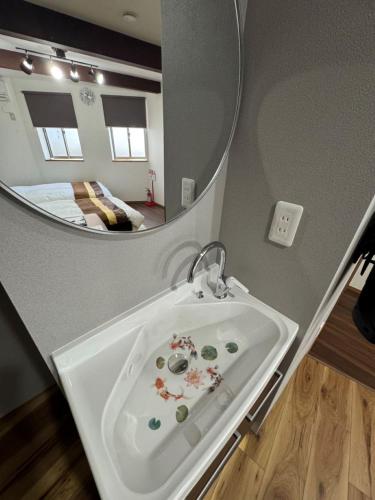 a bathroom with a white sink and a mirror at Swiss 1960 in Sumoto