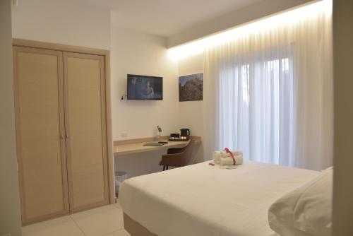 a bedroom with a bed and a desk with a computer at Hotel Floris in Rende
