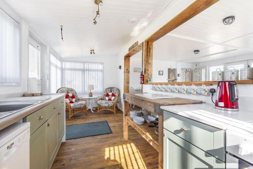 a kitchen with white cabinets and a wooden counter top at Violet in Heacham
