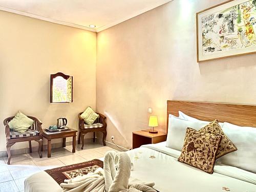 a hotel room with a bed and a table and chairs at Puri Anyar Ubud by Puri Signatures in Ubud