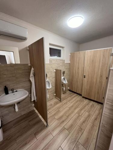 a bathroom with two urinals and a sink and toilets at Ezüst Mező Vendégház in Nagyecsed