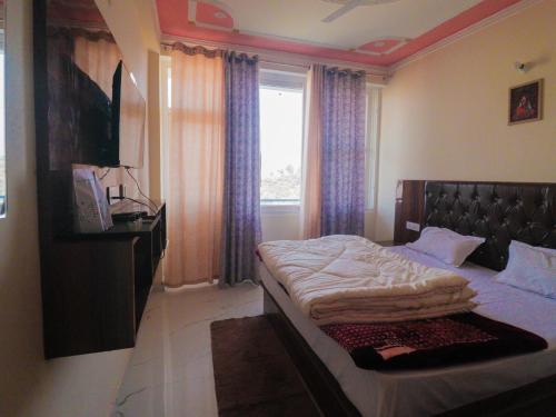 a bedroom with a large bed and a window at Corn Village Retreat in Mussoorie