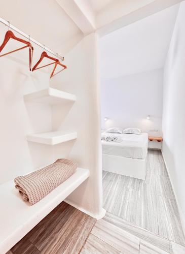 a white room with two beds and shelves at Castellino Naxos in Naxos Chora