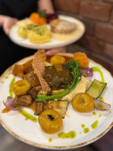 a plate of food with meat and vegetables on it at Zakarczmie Browar Wiejski in Leżajsk