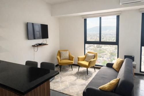 a living room with a couch and chairs and a flat screen tv at Suite en Torre Kyo Constella con vistas panorámicas in Monterrey