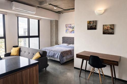 a room with a bed and a couch and a table at Suite en Torre Kyo Constella con vistas panorámicas in Monterrey
