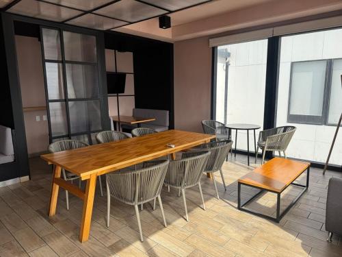 a dining room with a wooden table and chairs at Suite en Torre Kyo Constella con vistas panorámicas in Monterrey