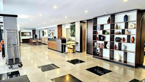 a lobby with a room with a table and shelves at Dynasty Grande Hotel in Bangkok