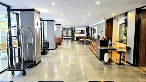 a lobby of a building with tables and chairs at Dynasty Grande Hotel in Bangkok