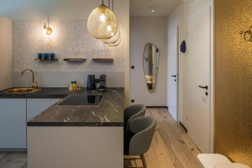 a kitchen with a sink and a counter with chairs at steiRerBLiCke - Gaberhö Gamlitz in Gamlitz