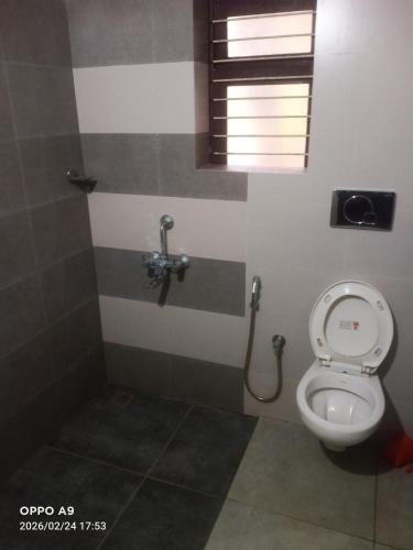 a bathroom with a toilet and a window at Nalukettu Veedu in Thottada