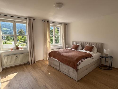 a bedroom with a bed and two windows at Faraway Homes Studio Mautern #8 in Mautern in Steiermark