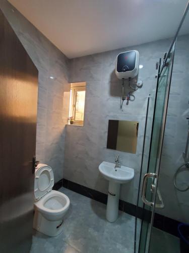 a bathroom with a toilet and a sink with a tv on the wall at Romeo Apartment in Ipaja