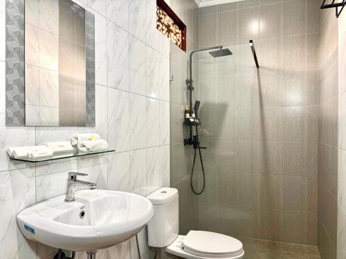 a bathroom with a sink and a toilet and a shower at Puri Anyar Ubud by Puri Signatures in Ubud