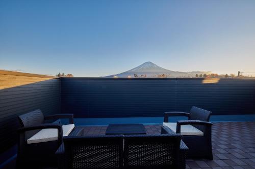 a patio with a table and chairs on a roof at MIYA HOUSE Kodachi A棟 in Fujikawaguchiko
