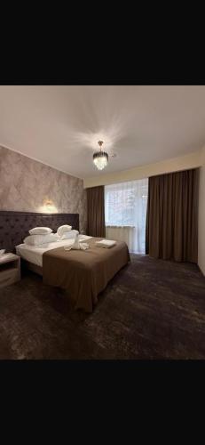 ein großes Schlafzimmer mit zwei Betten und einem Fenster in der Unterkunft Hotel Tiara in Ploieşti