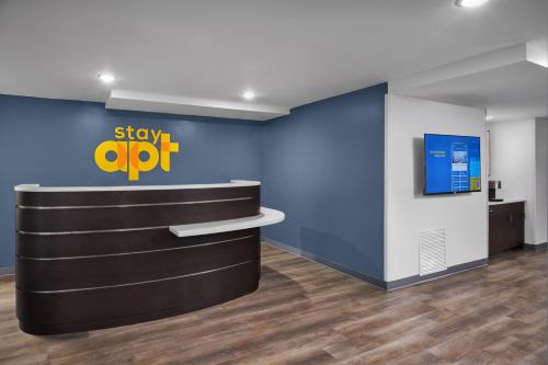 an office lobby with a stay app sign on the wall at stayAPT Suites Hampton in Hampton