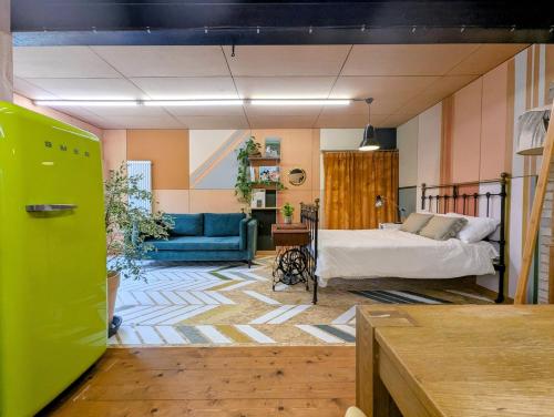 a bedroom with a bed and a blue couch at Woodside Studio in Hassocks