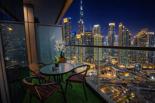 a table and chairs on a balcony with a city skyline at 2BR Burj Khalifa and Sea View Apartments in Paramount Hotel Midtown in Dubai
