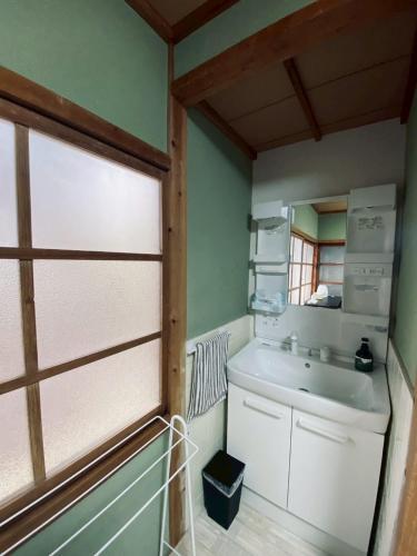 a bathroom with a sink and a mirror at おやど 瀬名 in Tanabe