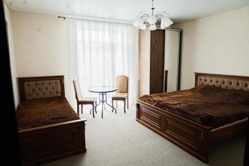 a bedroom with a bed and a table and chairs at готель-ресторан Дубок in Kvasy