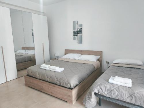 a bedroom with two beds and a mirror at Vitachiara Apartment - West Sicily Experience in Santa Ninfa