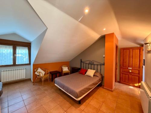 a bedroom with a bed and a table and chairs at Hostal El Horno in Molinaseca
