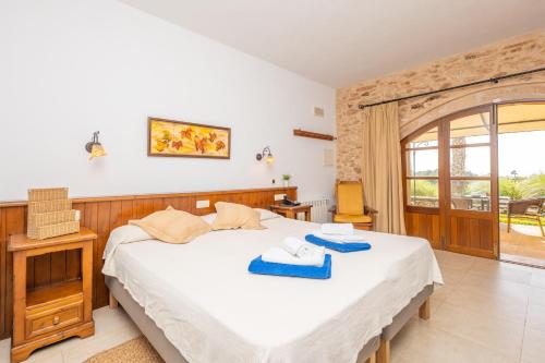 a bedroom with a bed with towels on it at Agroturismo Mondrago -Antic Na Martina- in Portopetro