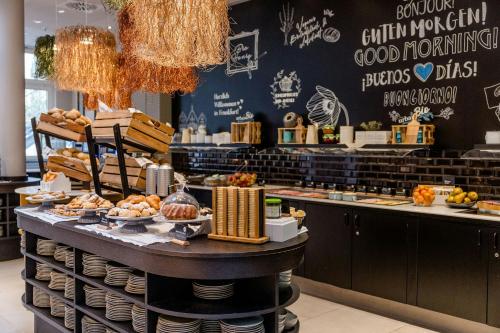 a bakery with a counter with food on it at Motel One Frankfurt-Hauptbahnhof in Frankfurt