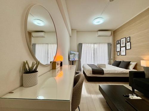 a living room with a bed and a mirror at Lion Heiwa Odori in Hiroshima