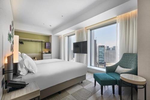 a hotel room with a bed and a large window at Centara Grand Hotel Osaka in Osaka