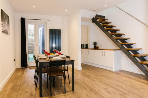a dining room and kitchen with a table and a staircase at Charming Coastal Retreat in BN2 in Brighton & Hove