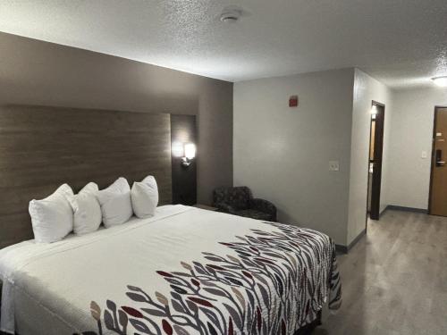 a hotel room with a large bed with white pillows at Red Roof Inn & Suites Hammond, IN in Hammond
