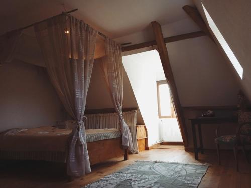 a bedroom with a canopy bed with a window at Gîte de Bontemps in Saint-Vincent-de-Cosse