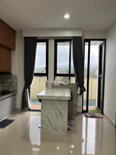 a kitchen with a large island in a room with windows at Athara Residence in Tlekung