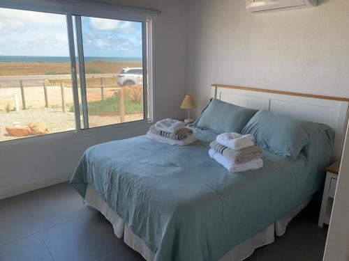a bedroom with a bed with towels on it and a window at Sur in Barra de Portezuelo