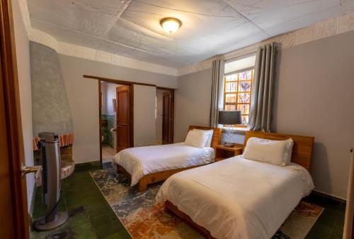 a bedroom with two beds and a window at Casa Historica Atitlán in Panajachel