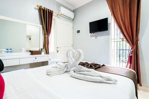 a bed with a towel in the shape of a heart at Fast Hous Syariah Bogor Mitra RedDoorz in Bogor