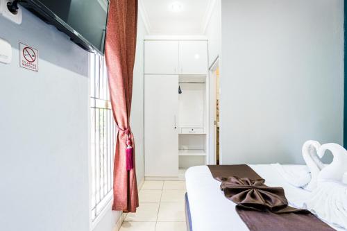 a bedroom with a bed and a swan towel at Fast Hous Syariah Bogor Mitra RedDoorz in Bogor