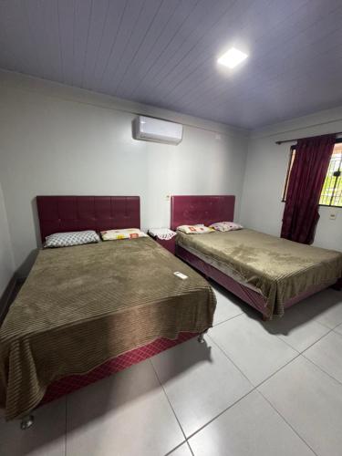 two beds sitting in a room with at Casa Saltos del Guiara in Salto del Guairá