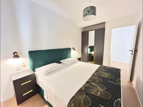 a bedroom with a large bed with a green headboard at Apartment San Pietro in Supetar