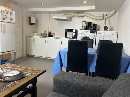 a kitchen with a table and two chairs and a table and a kitchen with at Basement Apartment in Villa in Odense